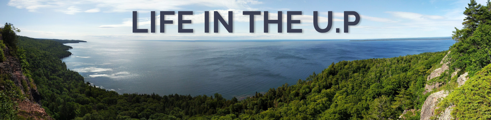 Panoramic view of Lake Superior and the forested shoreline of Michigan’s Upper Peninsula, highlighting the natural beauty and outdoor lifestyle available to professionals living and working in the U.P.